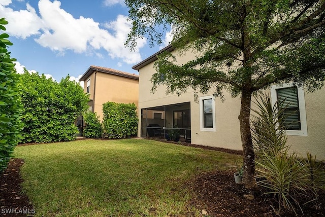 rear view of property featuring a sunroom and a yard