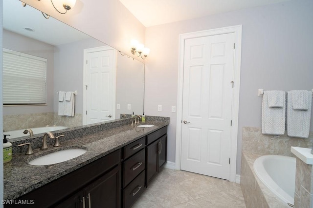 bathroom with tile patterned flooring, vanity, and a relaxing tiled tub