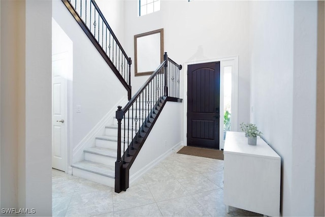 tiled entrance foyer with a towering ceiling