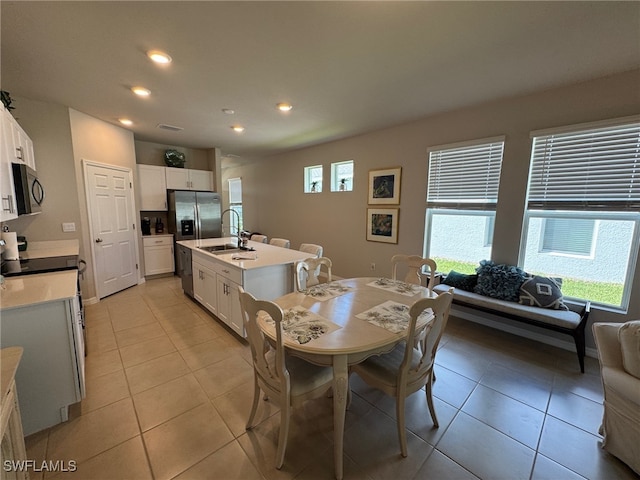 dining area featuring light tile patterned floors and sink