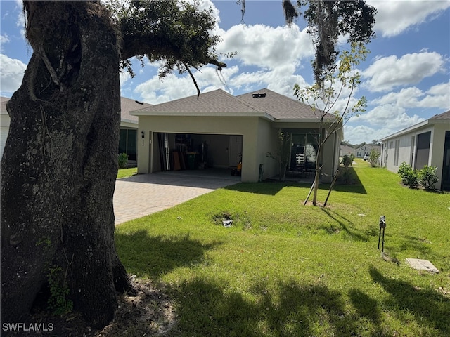 rear view of house with a garage and a yard