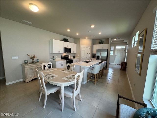 dining space featuring sink and light tile patterned flooring