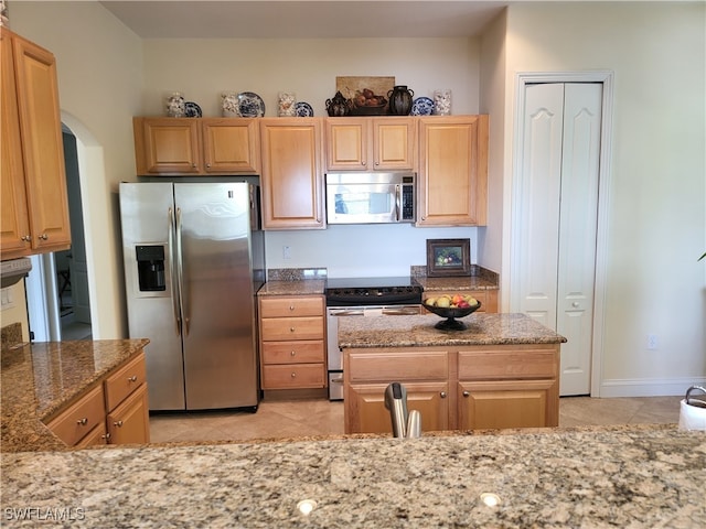 kitchen featuring light tile patterned flooring, appliances with stainless steel finishes, light brown cabinets, light stone countertops, and sink