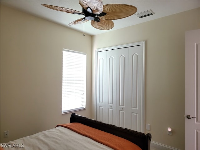 bedroom featuring multiple windows, ceiling fan, and a closet