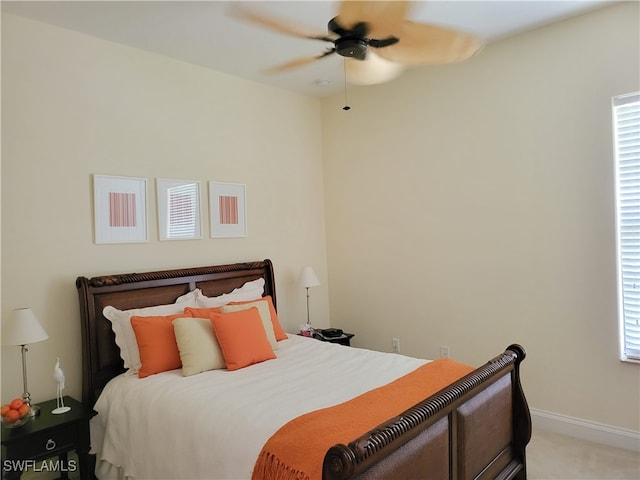 bedroom with light colored carpet, multiple windows, and ceiling fan