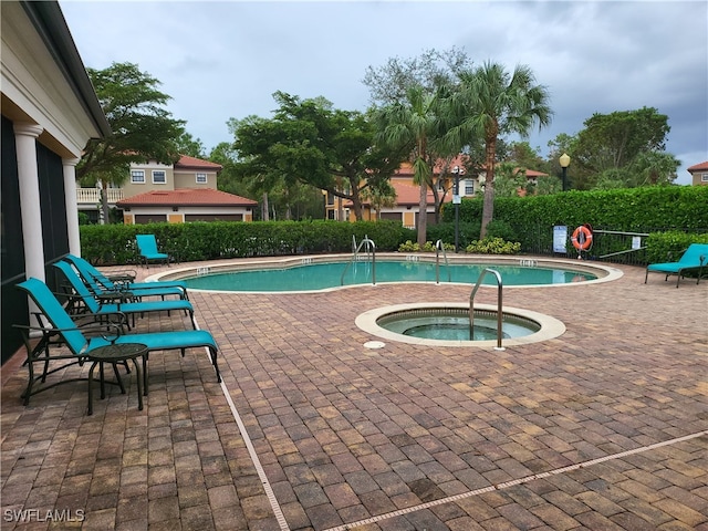 view of pool featuring a community hot tub and a patio area