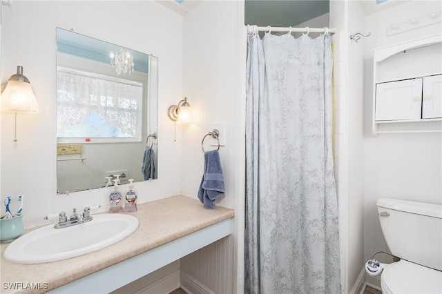 bathroom featuring a shower with curtain, vanity, toilet, and an inviting chandelier