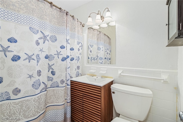 bathroom featuring tile walls, vanity, and toilet