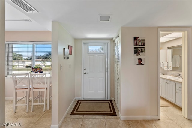 doorway to outside with sink and light tile patterned floors