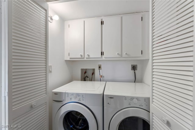 laundry room featuring washing machine and dryer and cabinets