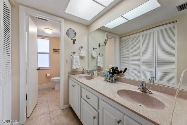 bathroom featuring vanity, tile patterned flooring, and toilet