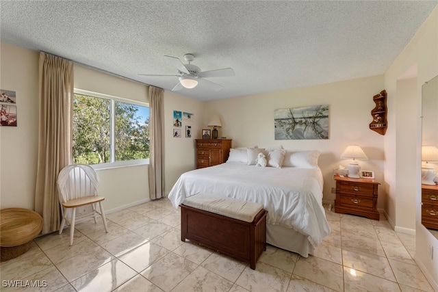 bedroom with ceiling fan and a textured ceiling