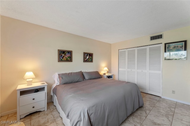 bedroom with a textured ceiling and a closet