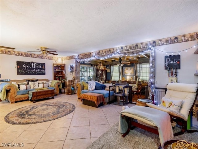 living room with ceiling fan, light tile patterned floors, and a textured ceiling