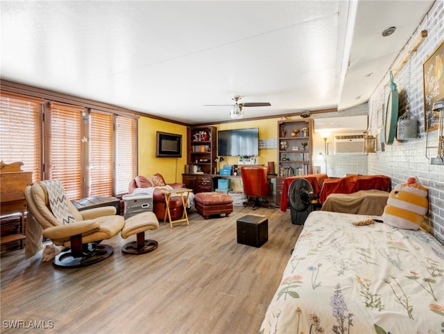 bedroom featuring ceiling fan, brick wall, hardwood / wood-style flooring, and ornamental molding