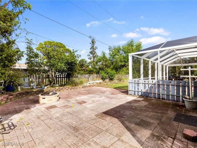 view of patio / terrace with a lanai and an outdoor fire pit