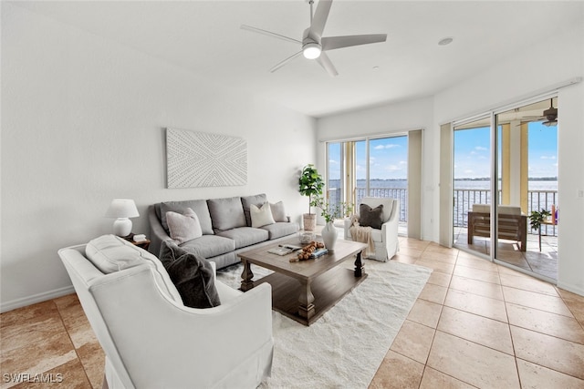 tiled living room with a water view and ceiling fan