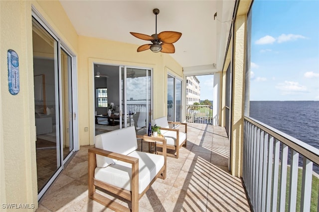 sunroom / solarium featuring ceiling fan and a water view