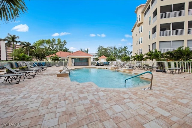 view of swimming pool featuring pool water feature and a patio