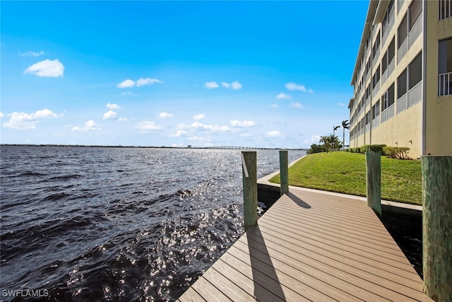 dock area featuring a water view and a lawn