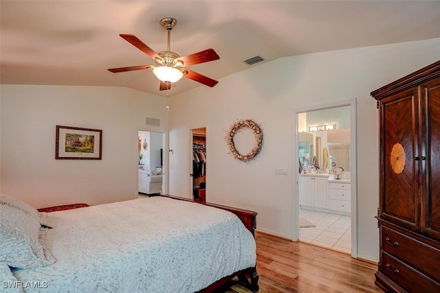 bedroom featuring ensuite bathroom, ceiling fan, a closet, light wood-type flooring, and a spacious closet