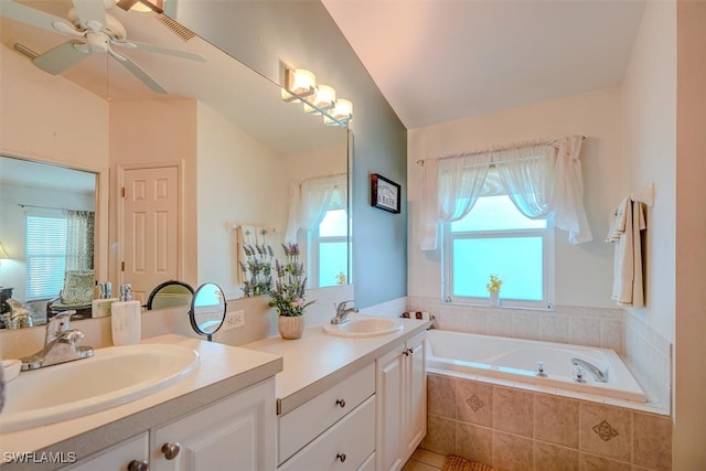 bathroom featuring vanity, vaulted ceiling, a relaxing tiled tub, and ceiling fan