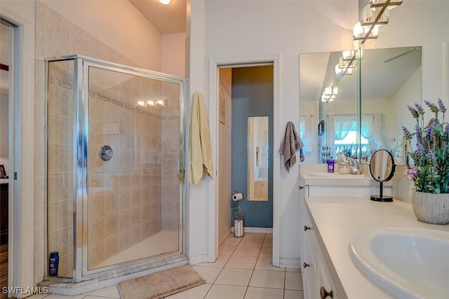 bathroom with walk in shower, vanity, and tile patterned floors