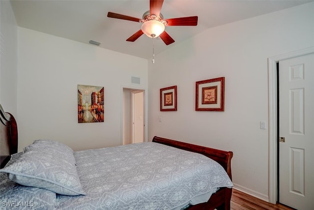 bedroom with lofted ceiling, hardwood / wood-style floors, and ceiling fan