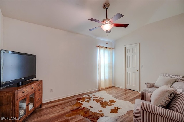 living room featuring ceiling fan, wood-type flooring, and lofted ceiling