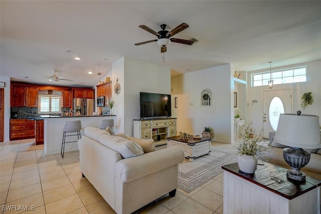 tiled living room with a wealth of natural light and ceiling fan