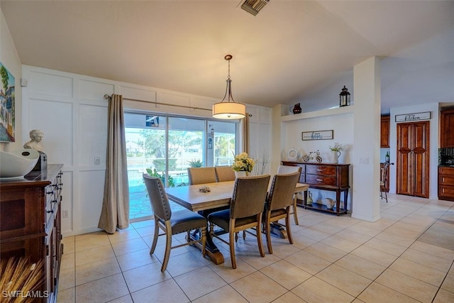 tiled dining space with lofted ceiling