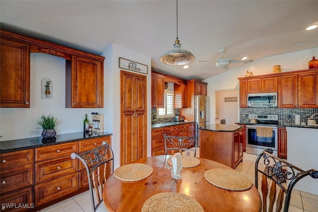 kitchen with vaulted ceiling, light tile patterned floors, ceiling fan, and stainless steel appliances