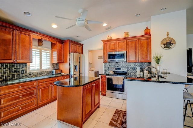 kitchen featuring stainless steel appliances, kitchen peninsula, tasteful backsplash, a kitchen bar, and lofted ceiling