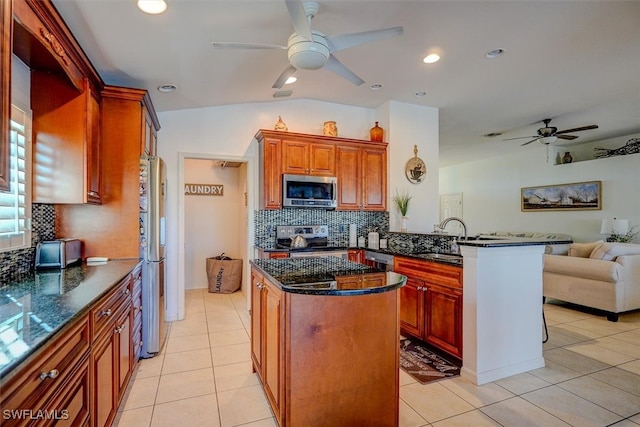 kitchen featuring stainless steel appliances, light tile patterned floors, sink, and backsplash