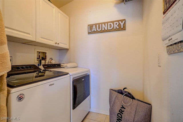 washroom with cabinets, light tile patterned floors, and washer and clothes dryer