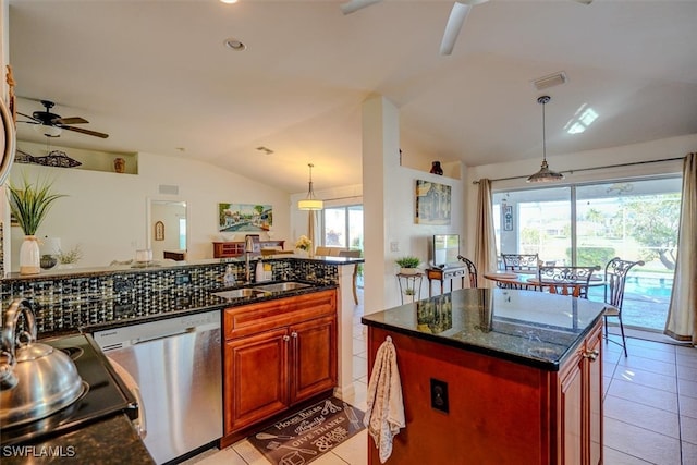 kitchen featuring vaulted ceiling, dishwasher, sink, a kitchen island with sink, and dark stone countertops