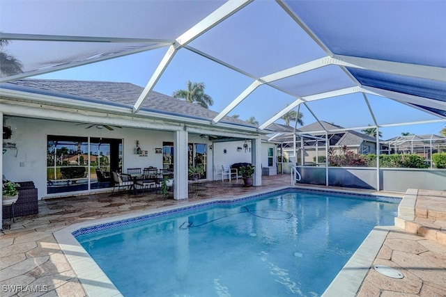 view of pool featuring ceiling fan, glass enclosure, and a patio area