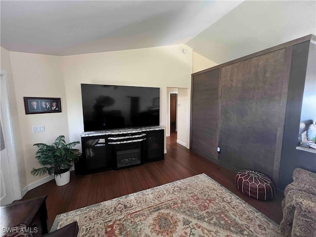 living room with dark hardwood / wood-style flooring and vaulted ceiling