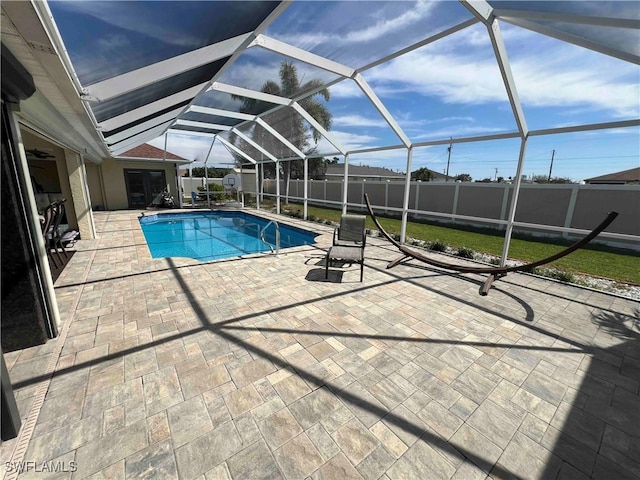 view of pool featuring glass enclosure and a patio area