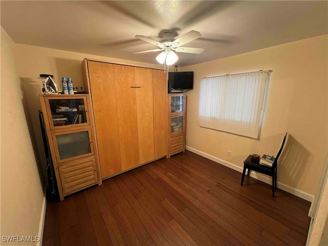 unfurnished bedroom featuring ceiling fan and dark hardwood / wood-style flooring