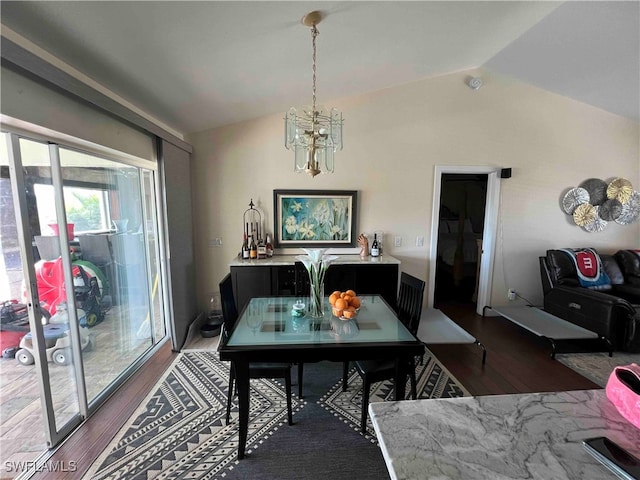 dining area with dark hardwood / wood-style floors, a chandelier, and vaulted ceiling