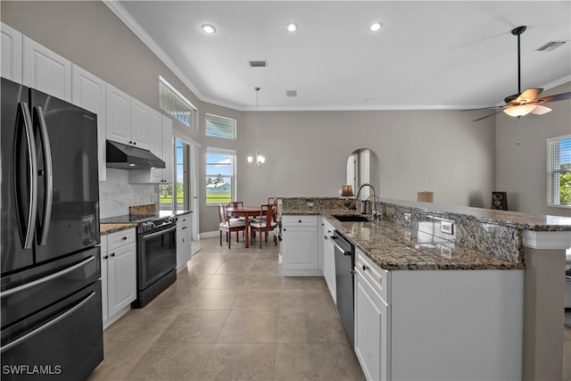 kitchen featuring black refrigerator, range with electric cooktop, white cabinetry, and a healthy amount of sunlight