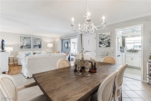 dining area with light tile patterned floors, a notable chandelier, crown molding, and sink