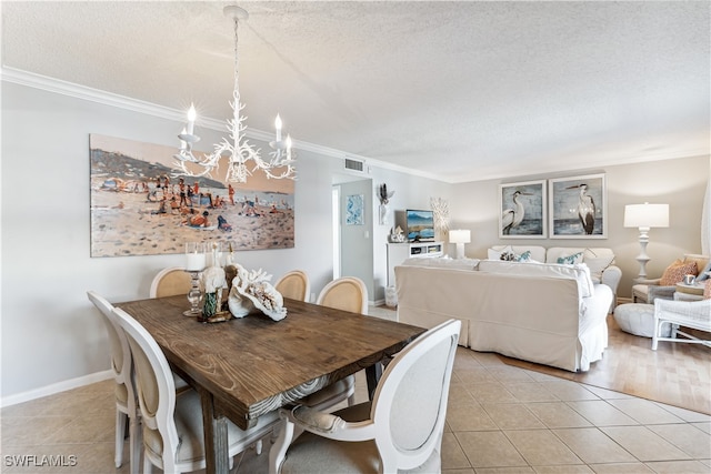 dining area featuring an inviting chandelier, crown molding, light tile patterned flooring, and a textured ceiling