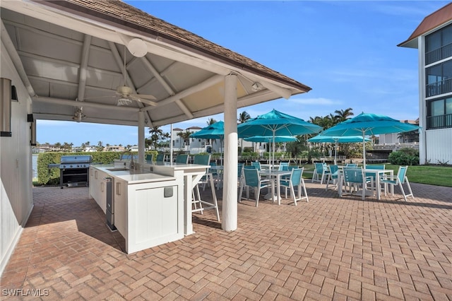 view of patio with area for grilling, ceiling fan, sink, and an outdoor kitchen