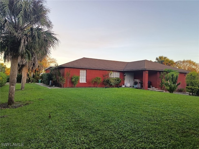 single story home with a lawn