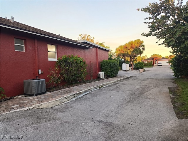 property exterior at dusk featuring central AC unit