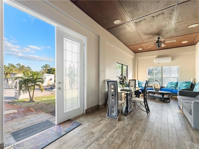 sunroom with an AC wall unit and ceiling fan