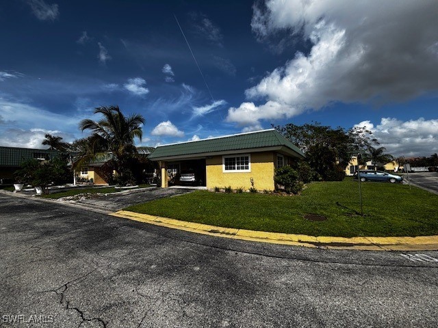 view of front of home featuring a front lawn and a carport