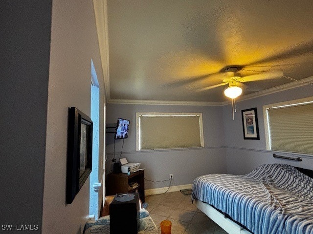 tiled bedroom featuring ceiling fan, a textured ceiling, and ornamental molding